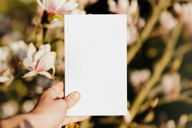 Realistic book cover mockup held in hand for author branding